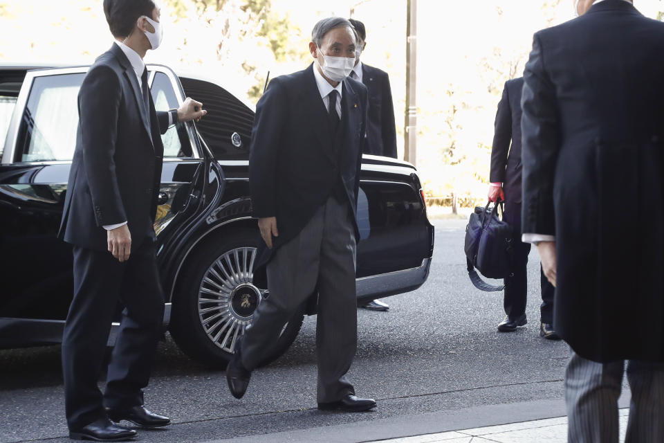 Prime Minister Yoshihide Suga wearing a face mask arrives at the National Theatre of Japan to attend the national memorial service for the victims of the March 11, 2011, earthquake and tsunami in Tokyo, Thursday, March 11, 2021. Japan is marking the 10th anniversary of the earthquake, tsunami and nuclear disaster with many survivors’ lives are still on hold. (Rodrigo Reyes Marin/Pool Photo via AP)