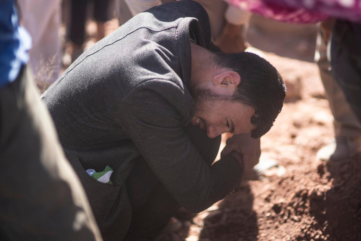 A man weeps after burying his brother who was killed by the earthquake, in Ouargane village (AP)