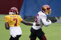 Washington quarterback Dwayne Haskins Jr. (7) hands the ball off to running back Adrian Peterson (26) during an NFL football practice at FedEx Field, Monday, Aug. 31, 2020, in Washington. (AP Photo/Alex Brandon)