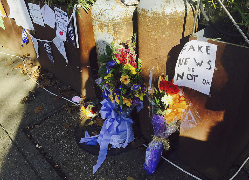 In this Dec. 9, 2016 photo, flowers and notes left by well-wishers outside Comet Ping Pong, the pizza restaurant in northwest Washington, D.C.,are shown, where a North Carolina man fired an assault rifle multiple times as he attempted to "self-investigate" the conspiracy theory known in the Twitterverse as "Pizzagate. (AP Photo/Jessica Gresko)