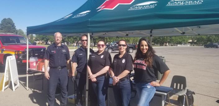 Carlsbad Community Anti-Drug/Gang Coalition Preventionist Lysondra Bartock (right) stands with members of the Carlsbad Police and Fire Departments April 20 at the Household Hazardous Waste Clean up Day at the Carlsbad Beach.