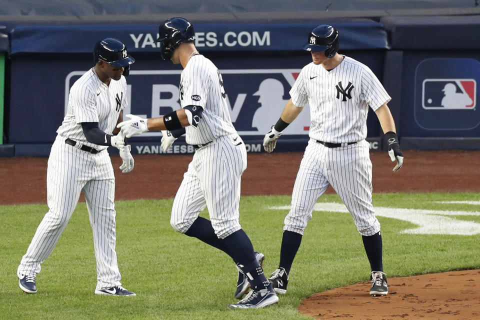 New York Yankees' Miguel Andujar, left, and DJ LeMahieu, right, celebrate with Aaron Judge, center, after Judge hit a three-run home run in the second inning of a baseball game against the Boston Red Sox, Sunday, Aug. 2, 2020, at Yankee Stadium in New York. (AP Photo/Kathy Willens)