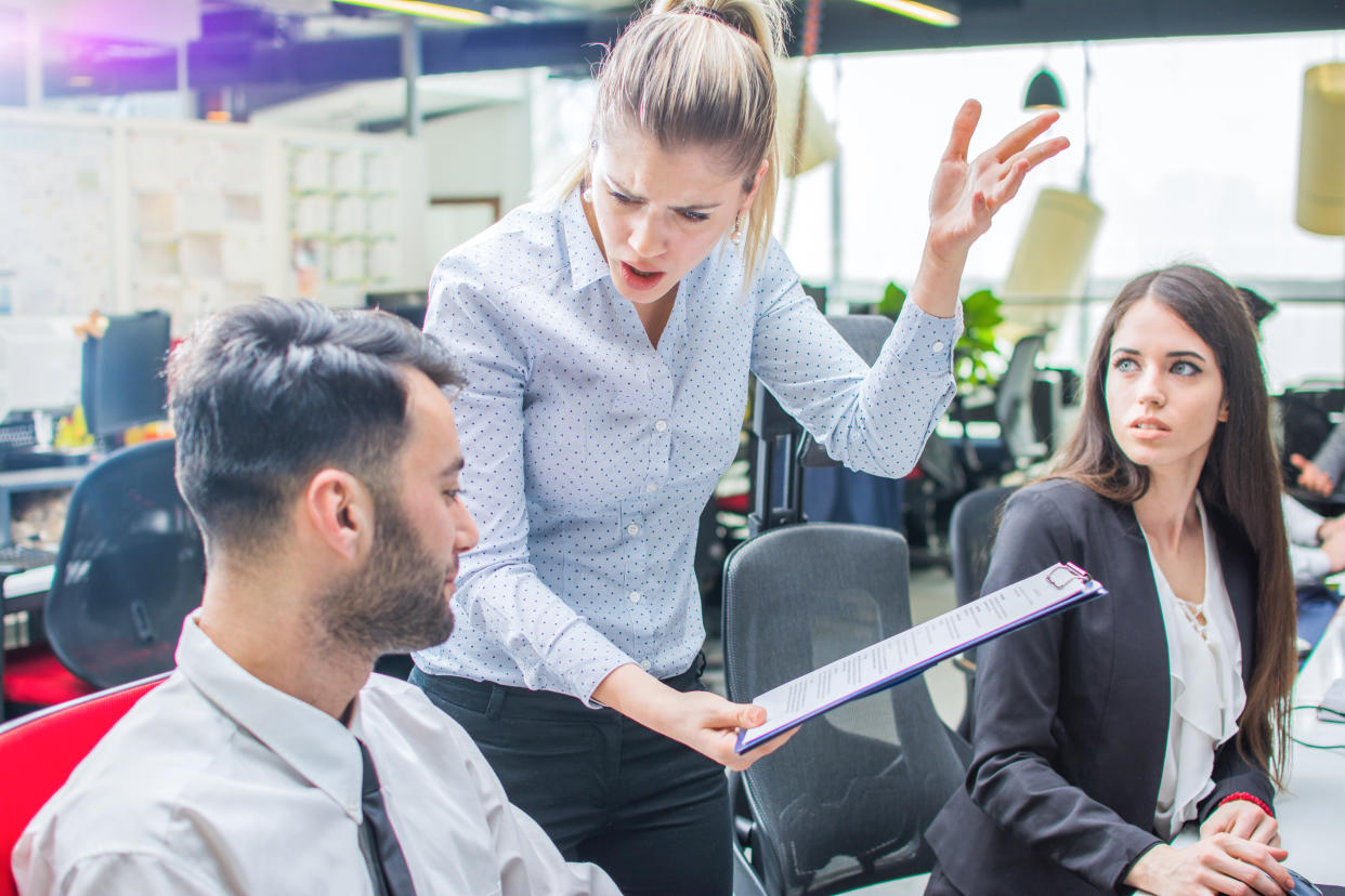 Angry businesswoman shouting to a stressed employee at office.