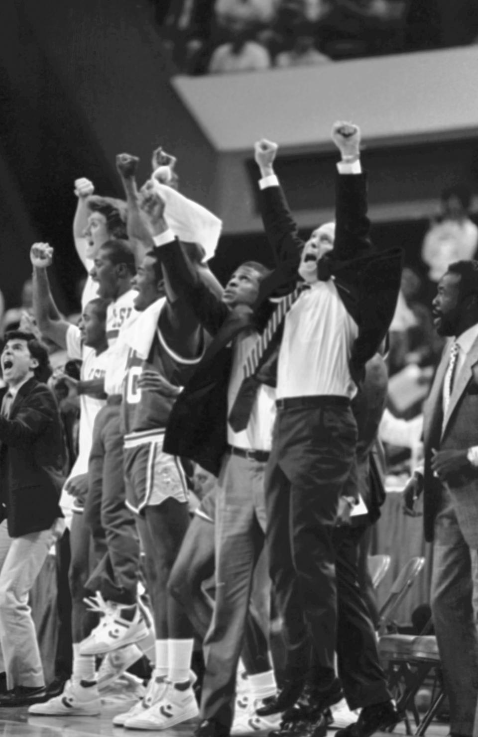 FILE - Louisiana State University coach Dale Brown, right, and team members on the sidelines raise their arms in victory after defeating Kentucky in the NCAA college basketball southeast finals to advance to the Final Four in Dallas, March 22, 1986. (AP Photo/File)