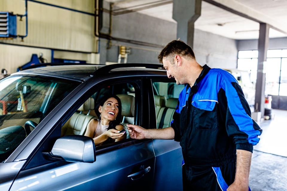 Mechanic is Giving Car Keys to a Young Businesswoman After he had Repaired her Car, pre-trip vehicle maintenance