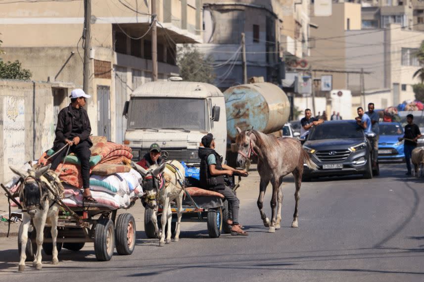 以色列空襲後，加薩市的巴勒斯坦人13日帶著財物逃亡更安全的地方。（法新社）
