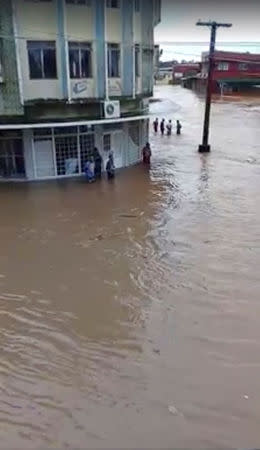 People stand in a flooded area in Ba, Viti Levu, Fiji in this still image taken from a social media video from April 1, 2018. COURTESY of SANJEET RAM /via REUTERS