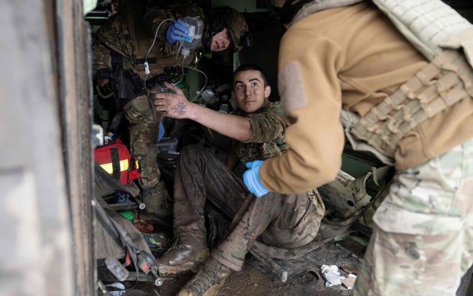 Medics from the Da Vinci Wolves Battalion evacuate a lightly wounded Ukrainian serviceman near the front line of Bakhmut, Donetsk - Genya SAVILOV / AFP