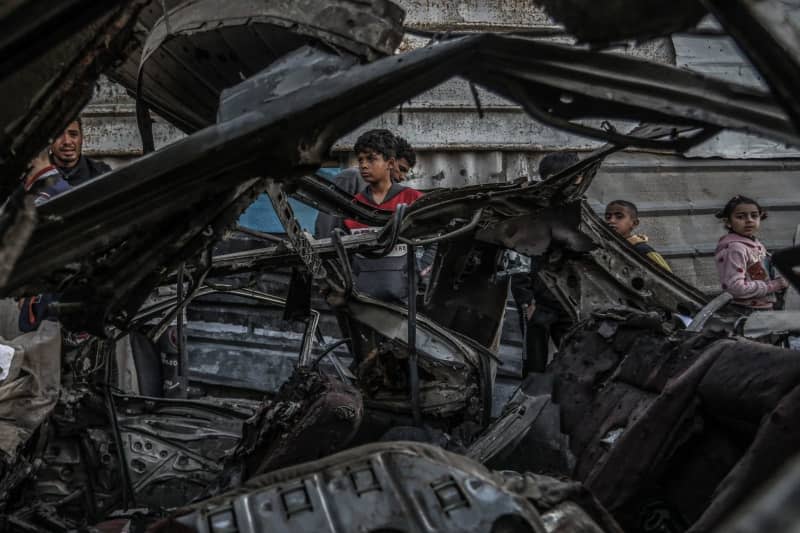 Palestinians inspect a vehicle destroyed by an Israeli military drone, where two persons were killed and others injured, according to the Gaza Ministry of Health. Abed Rahim Khatib/dpa