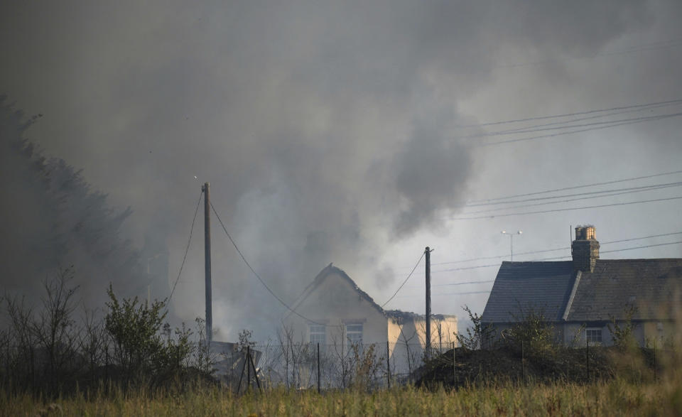 A blaze is in the village of Wennington, east London, Tuesday, July 19, 2022. The typically temperate nation of England is the latest to be walloped by unusually hot, dry weather that has triggered wildfires from Portugal to the Balkans and led to hundreds of heat-related deaths. (Yui Mok/PA via AP)