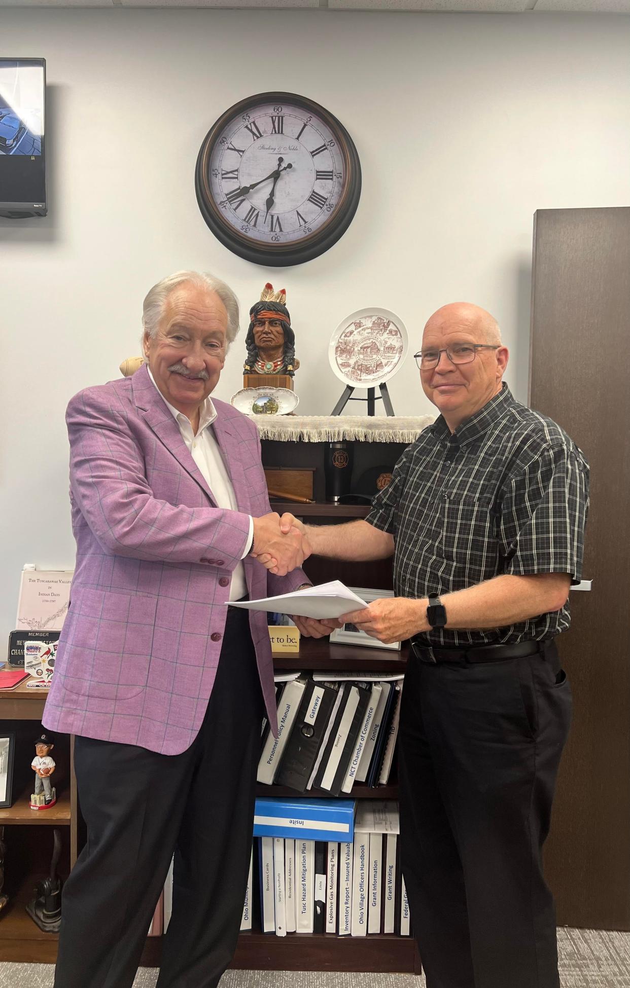 Bill Heifner and Mayor Pat Cadle shake hands at a recent Newcomerstown Village Council meeting, where Heifner donated land to the village that will be the future site of a restaurant.