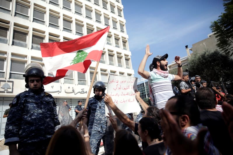 Police officers stand guard after protesters knocked down the fencing as they demonstrate outside of Lebanon Central Bank during ongoing anti-government protests in Beirut