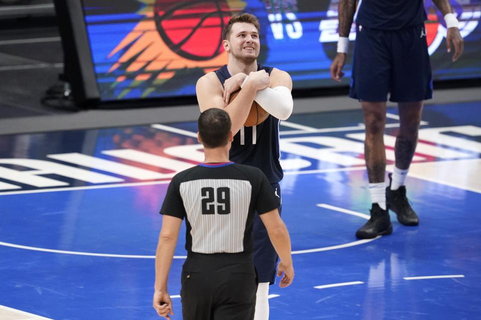 Dallas Mavericks' Luka Doncic, center, grabs the ball after referee Mark Lindsay (29) called a foul against center Willie Cauley-Stein in the second half in Game 3 of an NBA basketball first-round playoff series again the Los Angeles Clippers in Dallas, Friday, May 28, 2021. (AP Photo/Tony Gutierrez)