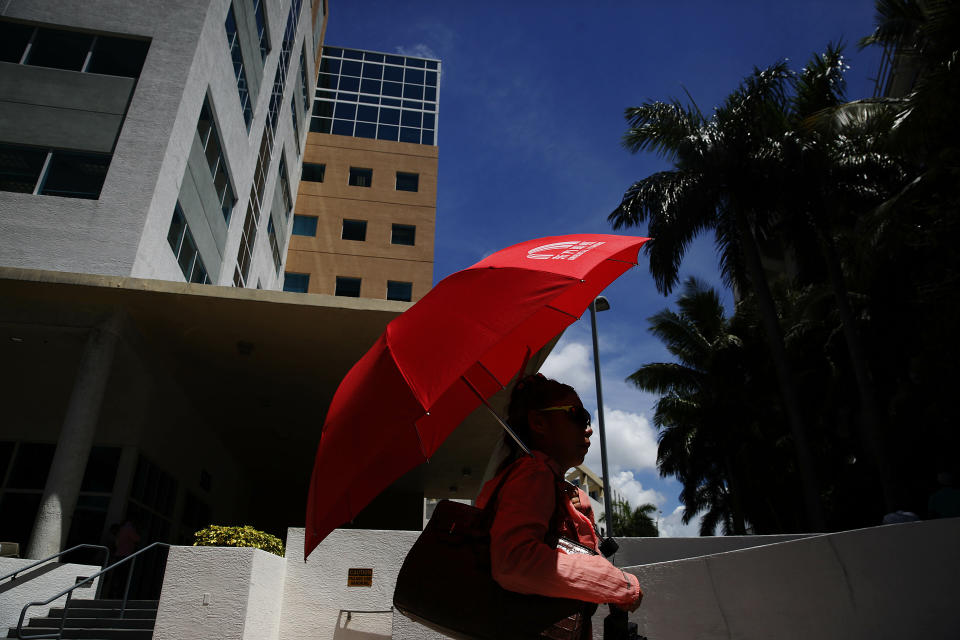 In this June 12, 2019, photo, a woman walks in front of immigration court in Miami. The Trump administration has appointed more than 4 in 10 of the country’s sitting immigration judges in a hiring surge that comes as U.S. authorities seek to crack down on immigration. (AP Photo/Brynn Anderson)