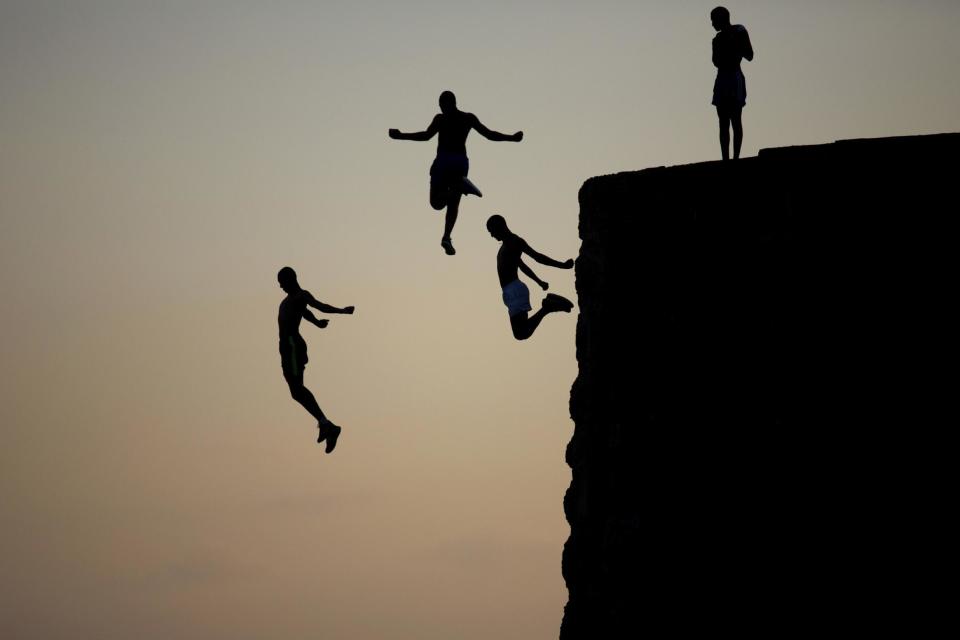 FILE - Israeli Arab boys jump into the Mediterranean sea from the ancient wall surrounding the old city of Acre, northern Israel, Tuesday, Aug. 2, 2016. (AP Photo/Ariel Schalit, File)