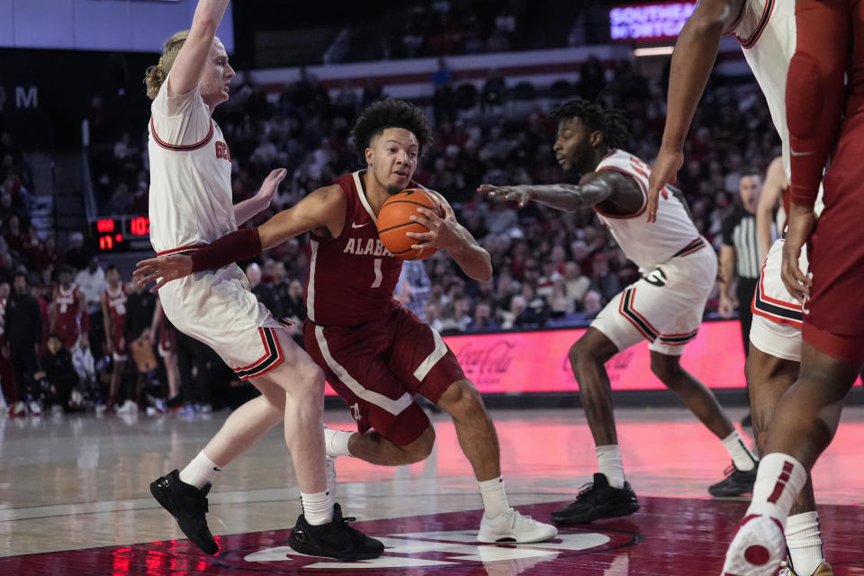 Alabama guard Mark Sears (1) drives between Georgia's Blue Cain (0) and Dylan James (13) in the first half of an NCAA college basketball game Wednesday, Jan. 31, 2024, in Athens, Ga. (AP Photo/John Bazemore)