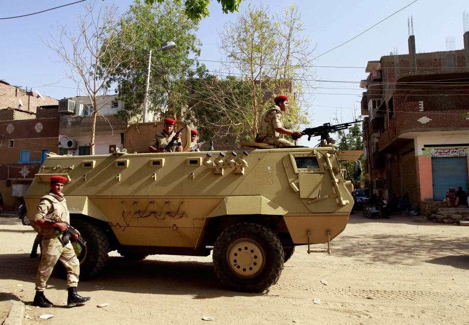 Egyptian military forces stand guard as Egyptian prosecutor general, Hisham Barakat, tours the area where fighting took place on Friday, April 4, between a Nubian family and members of the Arab Haleyla clan, in the southern city of Aswan, Egypt, Tuesday, April 8, 2014. Telephone and internet networks were briefly shut down to Egypt’s southern province of Aswan for several hours, as authorities moved to try to end a bloody tribal feud that killed tens the past week, security officials and residents said Tuesday. (AP Photo/Sabry Khaled, El Shorouk Newspaper) EGYPT OUT