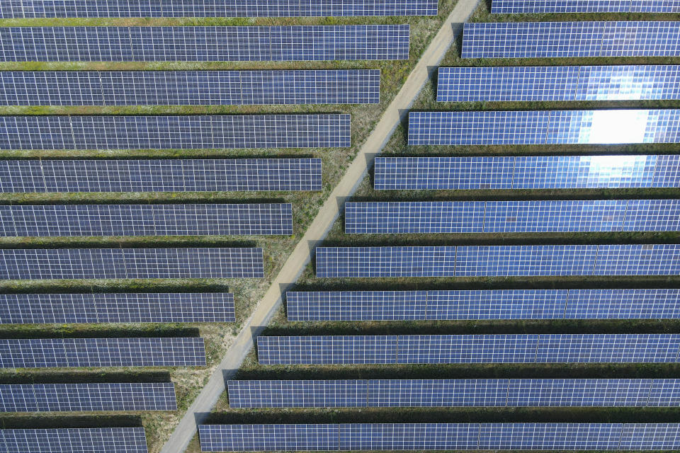 FILE - The sun reflected in solar panels of the EnBW solar park at Gottesgabe, Germany, Friday, July 1, 2022. To meet the goal of limiting global warming to 1.5 degrees Celsius (2.7 degrees Fahrenheit), nine major Asian economies must increase the share of electricity they get from renewable energy from the current 6% to at least 50% by 2030, according to a report by a German thinktank released Wednesday, Nov. 15, 2023. (Patrick Pleul/dpa via AP, File)