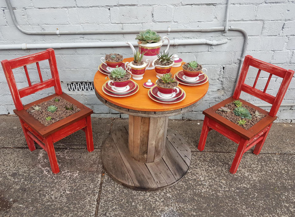 In this May 24, 2020 photo provided by Rick Everett, a small table decorated with succulents sits below a window where Everett offers free coffee and conversation to friends and neighbors at his home in Sydney, Australia during the coronavirus pandemic. (Rick Everett via AP)