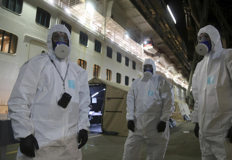 In this Wednesday, April 8, 2020, photo provided by the New South Wales Police, investigators in protective gear prepare to board the Ruby Princess cruise ship at Wollongong, Australia. Police boarded the cruise ship to seize evidence and question crew members after the vessel was linked to hundreds of COVID-19 cases and more than a dozen deaths across Australia. (Nathan Patterson/NSW Police via AP)