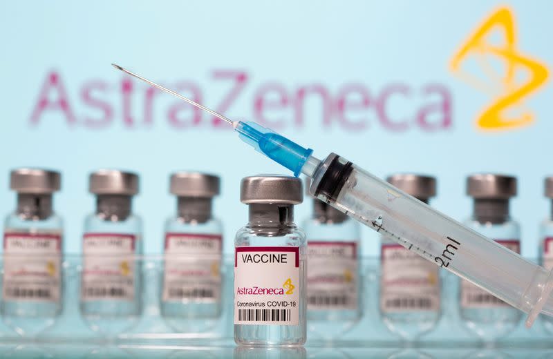 FILE PHOTO: Vials labelled "AstraZeneca COVID-19 Coronavirus Vaccine" and a syringe are seen in front of a displayed AstraZeneca logo