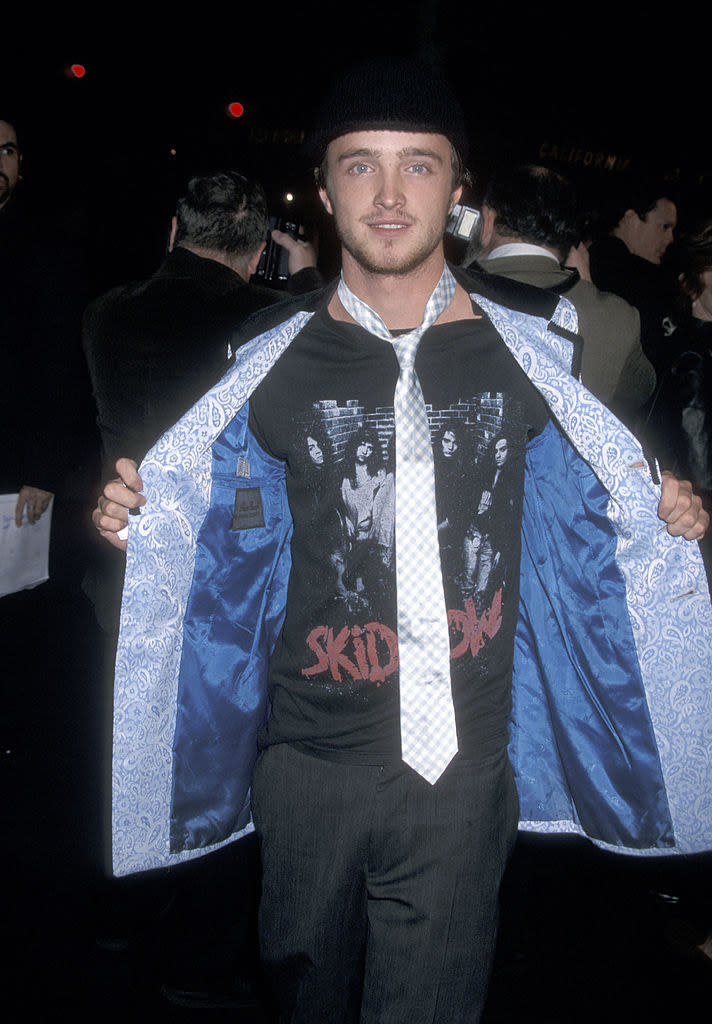 Aaron holding open his jacket to display a Skid Row T-shirt