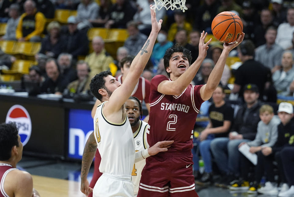 Stanford guard Andrej Stojakovic, right, is fouled while driving to the basket by Colorado guard Luke O'Brien, center left, in the first half of an NCAA college basketball game Sunday, March 3, 2024, in Boulder, Colo. (AP Photo/David Zalubowski)