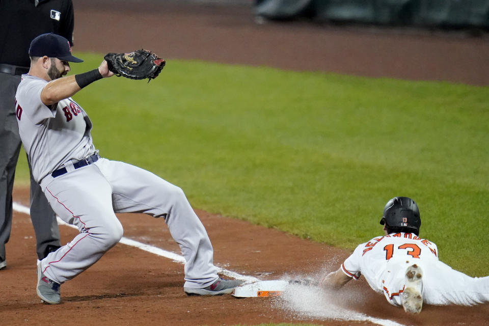 Boston Red Sox first baseman Mitch Moreland, left, steps on the bag while Baltimore Orioles' Andrew Velazquez makes a head first slide while trying to beat a ground out during the fifth inning of a baseball game, Thursday, Aug. 20, 2020, in Baltimore. (AP Photo/Julio Cortez)