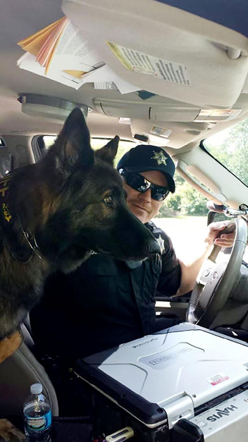 A photo of retired Wayne County Sheriff''s Deputy Richard Brooks and his dog Gunner while on duty. Gunner is buried at the War Dog Memorial cemetery in South Lyon.