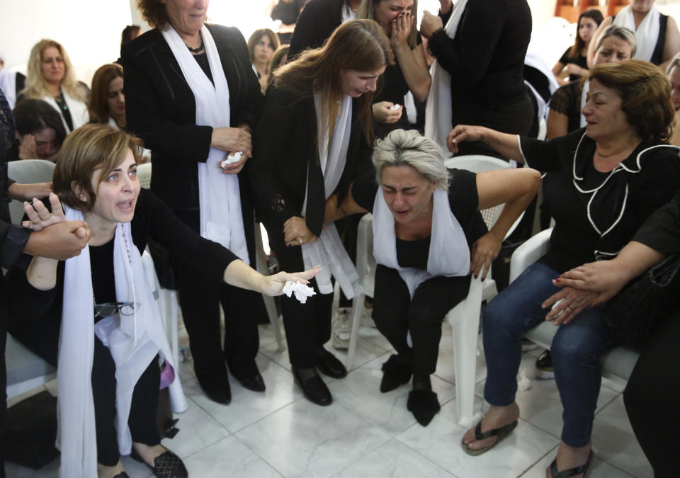 Lara, center right, the wife of Alaa Abu Fakher, a local official with the Progressive Socialist Party who killed by a Lebanese soldier during Tuesday night protests south of Beirut, mourns her husband with other relatives, in Choueifat neighborhood, Lebanon, Wednesday, Nov. 13, 2019. Lebanese protesters are blocking major highways with burning tires and roadblocks, saying they will remain in the streets following a televised interview in which the president urged them to go home. (AP Photo/Hussein Malla)