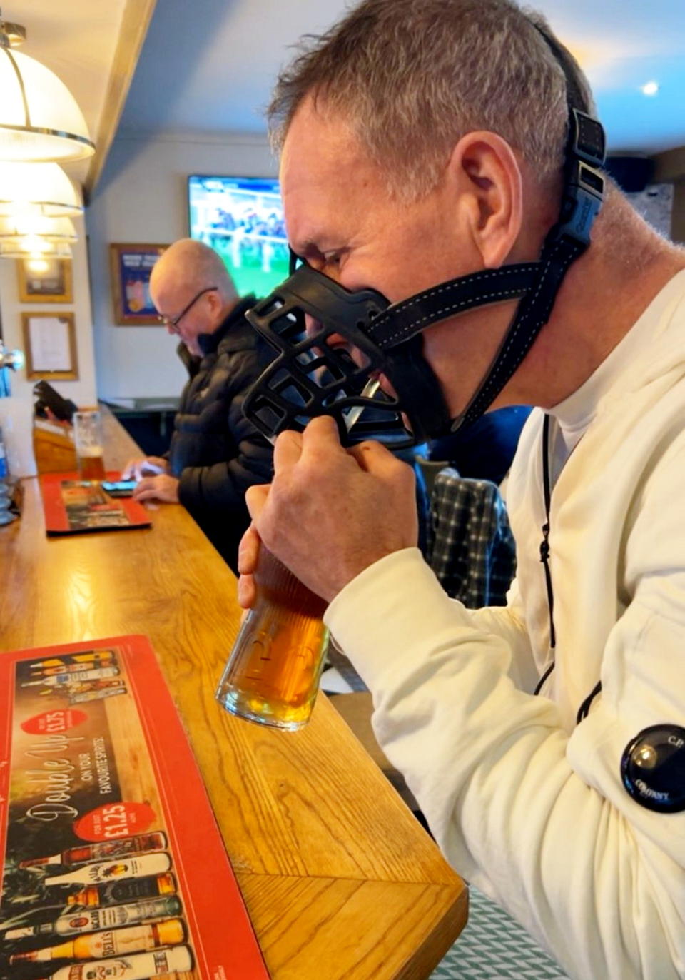Eamonn Mcgeady kdrinking his pint through a straw. Release date – January 4, 2024.  See SWNS story SWSYmuzzle.  A dad held a one-man protest over new XL bully laws - by drinking in his local pub with a muzzle on.  Eamonn Mcgeady, walked to the pub with the mask on - and then sat at the bar and drunk his pint through a straw.  He visited the boozer on New Year's Day with his daughter Elle Mcgeady, who owns six-month-old XL bully Lexi.  Eamonn didn't want to speak about the stunt - but Elle, 19, said he did it to make a point about new legislation on the breed. 