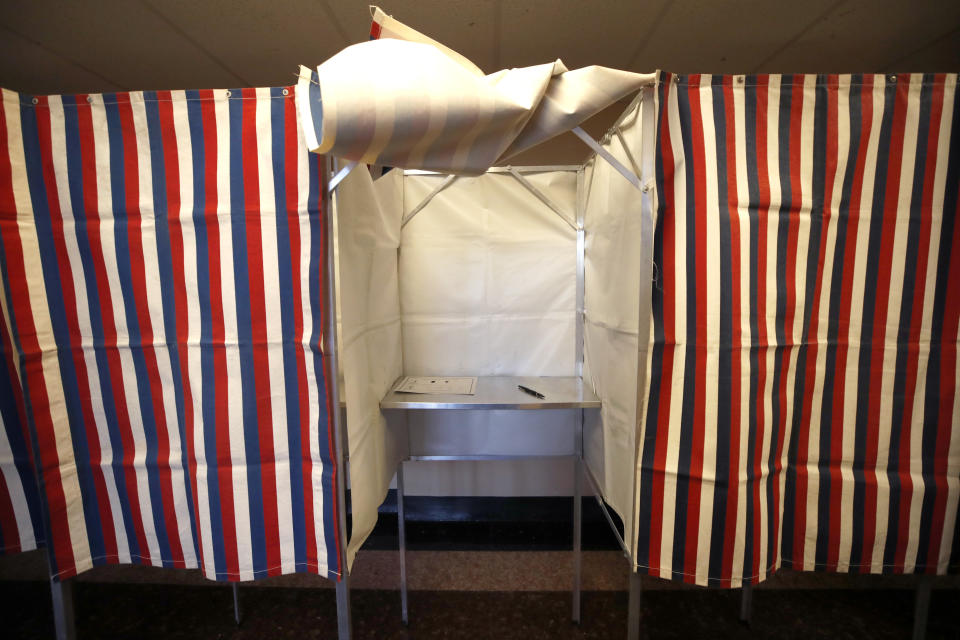 FILE - In this Feb. 24, 2020, file photo a booth is ready for a voter at City Hall in Cambridge, Mass. As college campuses reopen with more online learning, political campaigns, parties and voter registration groups face growing challenges in getting students registered. But registering them is just half the battle. In the coronavirus era, experts warn students are less likely to have their ballots count. The lack of in-person registration drives and traditional voter outreach events is contributing to a notable drop in new registrations, which could hurt Democrats in the 2020 general election. (AP Photo/Elise Amendola, File)