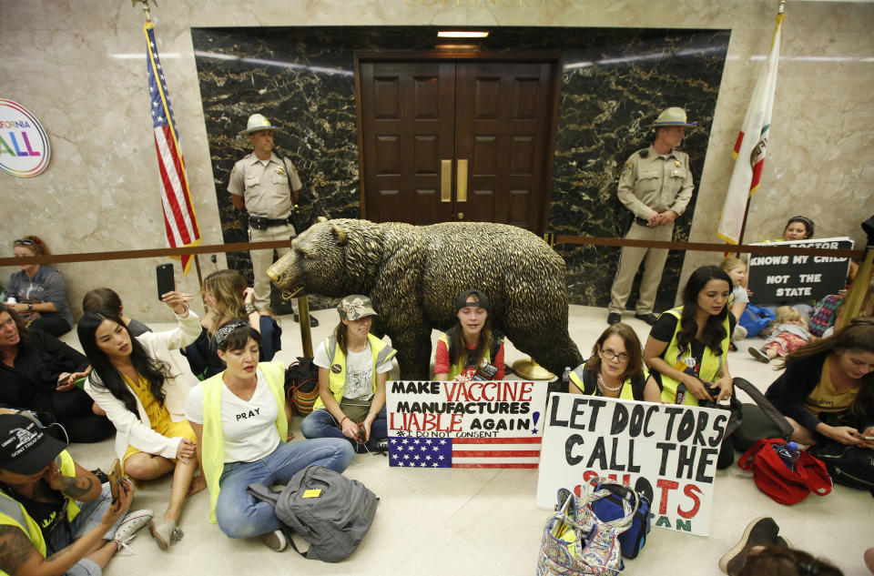 Opponents of a measure that would give public health officials oversight of doctors that may be giving fraudulent medical exemptions from vaccinations during gathered in front of the governor's office after it was approved by the Assembly Health Committee at the Capitol in Sacramento, Calif., Thursday, June 20, 2019.(AP Photo/Rich Pedroncelli)