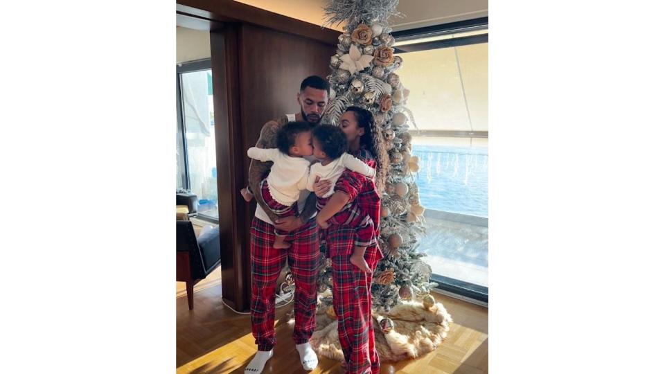 Leigh-Anne Pinnock and Andre Gray holding twin children by a Christmas tree