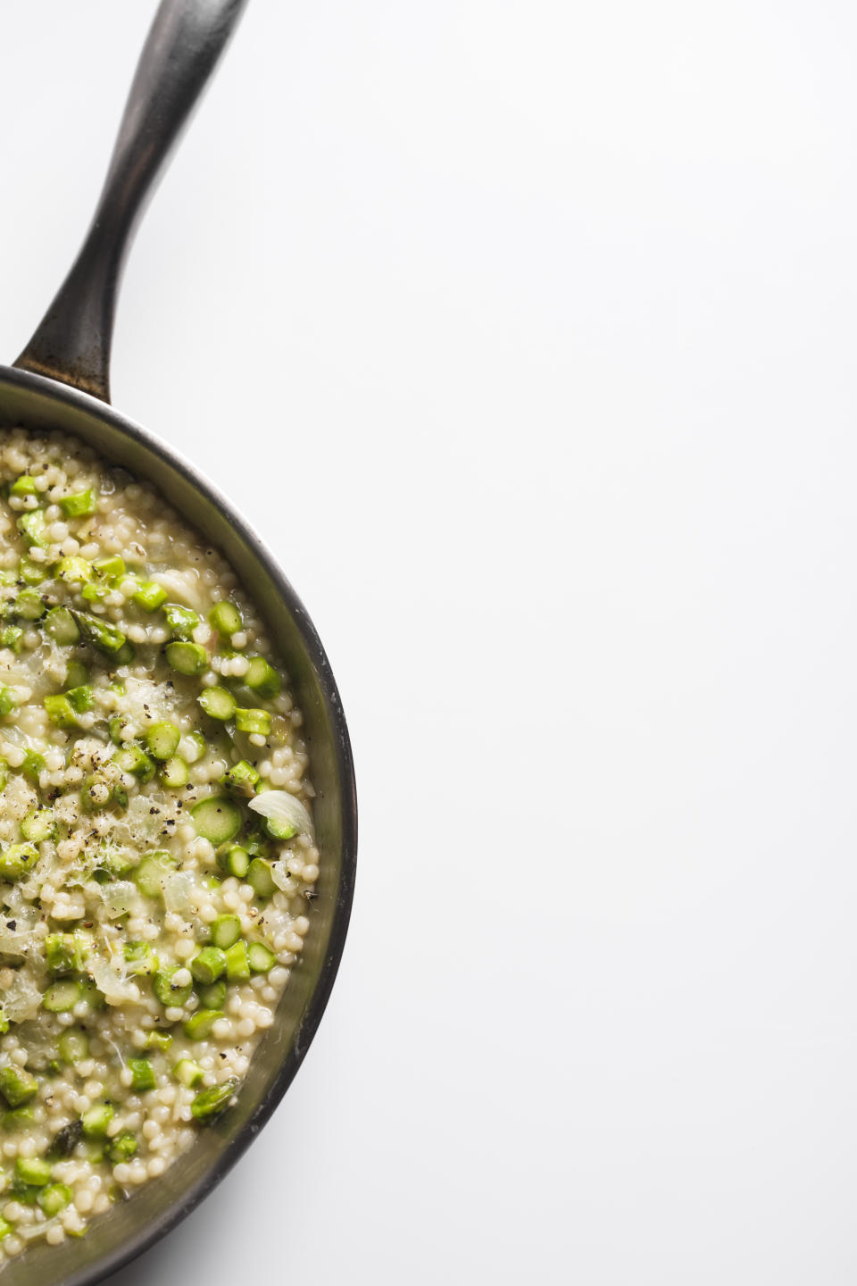 This image released by Milk Street shows a recipe for Couscous Risotto with Asparagus. (Milk Street via AP)