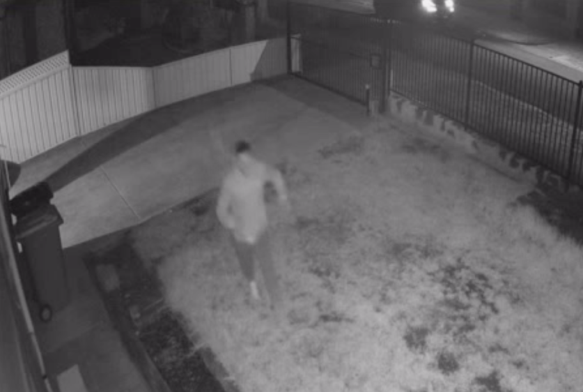A still from CCTV footage showing a man sprinting across a Melbourne front yard as a Porsche flees the scene.