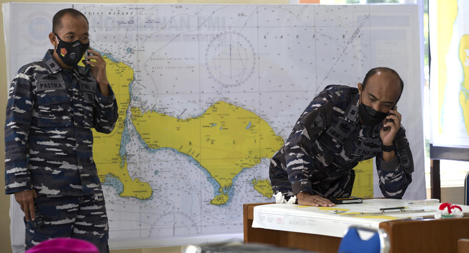 Indonesian military officials speak on the phone in front of a map of the location where the Indonesian Navy submarine KRI Nanggala that went missing while participating in a training exercise on Wednesday.