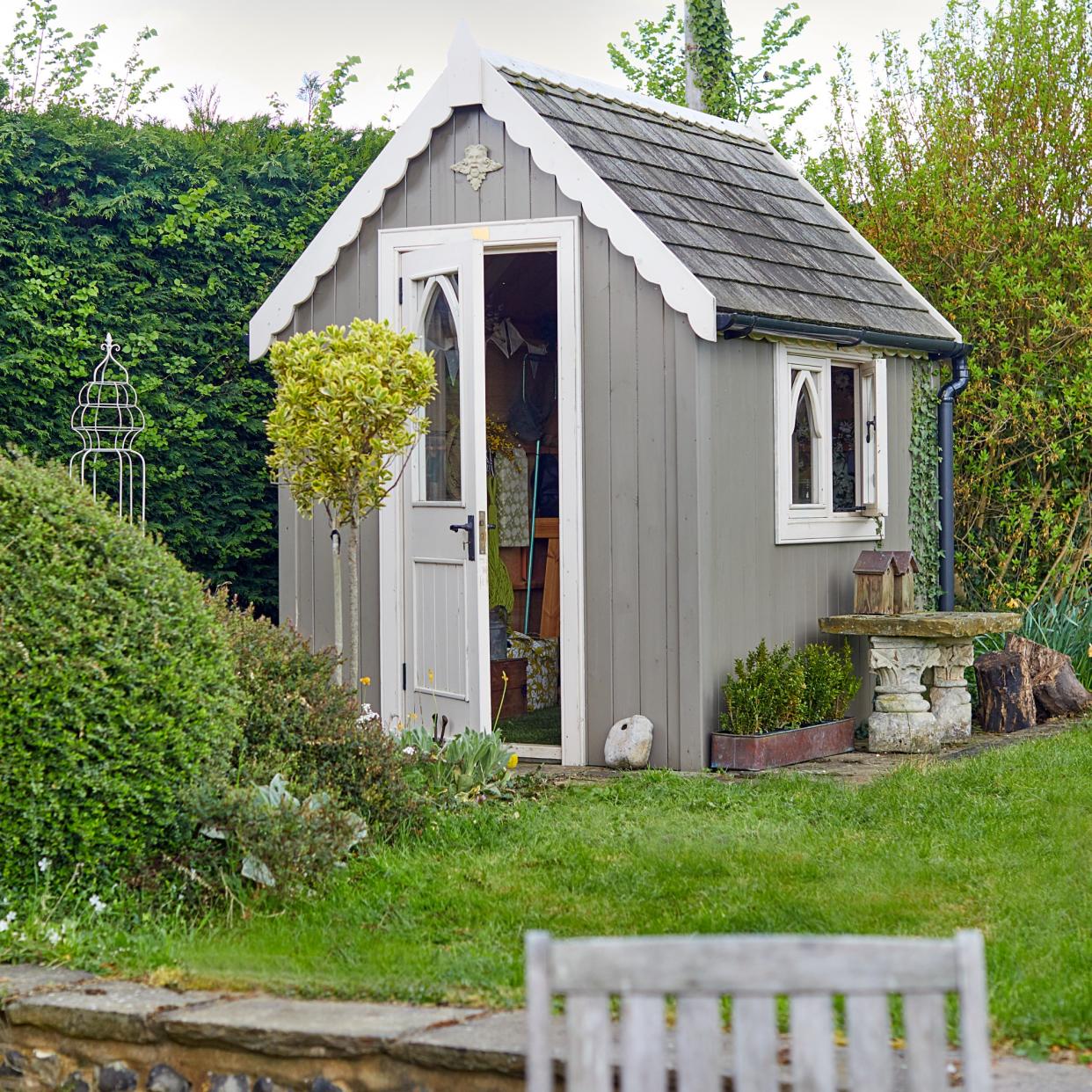  A garden with a shed and green lawn. 