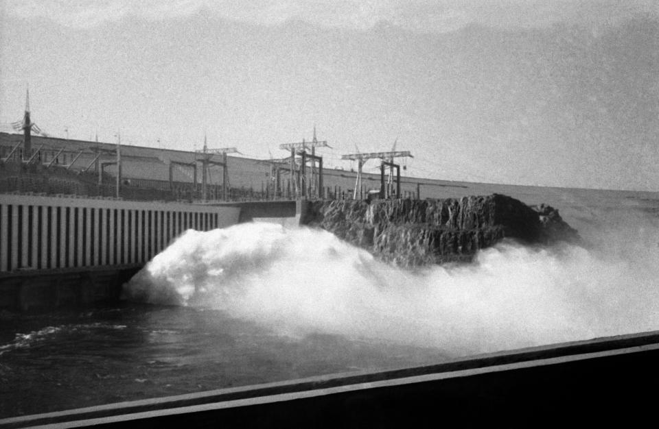 HOLD FILE - In this Jan. 15, 1971 file photo, water flows into the Aswan high dam after the inauguration ceremony in Aswan, Egypt. Egyptians are marking 50 years since the inauguration of the Nile dam, a massive feat of construction that has shaped the course of modern-day Egypt. It spared it from seasonal droughts and flooding, and generated electricity. (AP Photo, File)