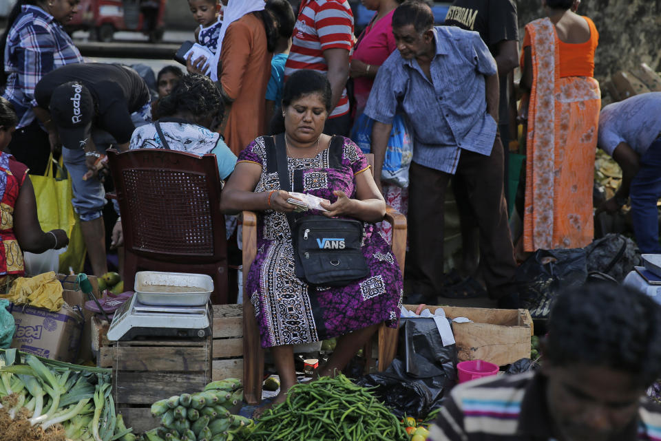 In this July 25, 2019, photo, a Sri Lankan vendor counts money at a market place in Colombo, Sri Lanka. Shocks from deadly suicide bombings on Easter Day in Sri Lanka are reverberating throughout its economy in the worst crisis since the South Asian island nation’s civil war ended in 2009. The blasts have devastated Sri Lanka’s vital tourism industry, source of jobs for many, and hindering foreign investment. (AP Photo/Eranga Jayawardena)