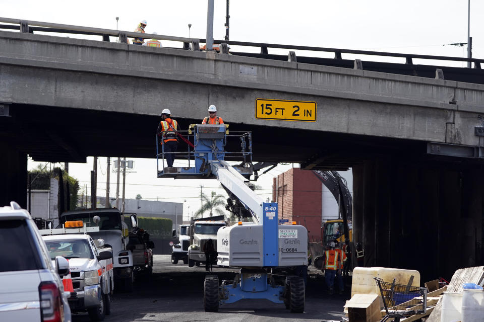 Workers begin repairs at the site of a weekend fire which caused the closure of Interstate 10, Monday, Nov. 13, 2023, in Los Angeles. Drivers are being tested in their first commute since a weekend fire that closed a major elevated interstate near downtown. (AP Photo/Ryan Sun)