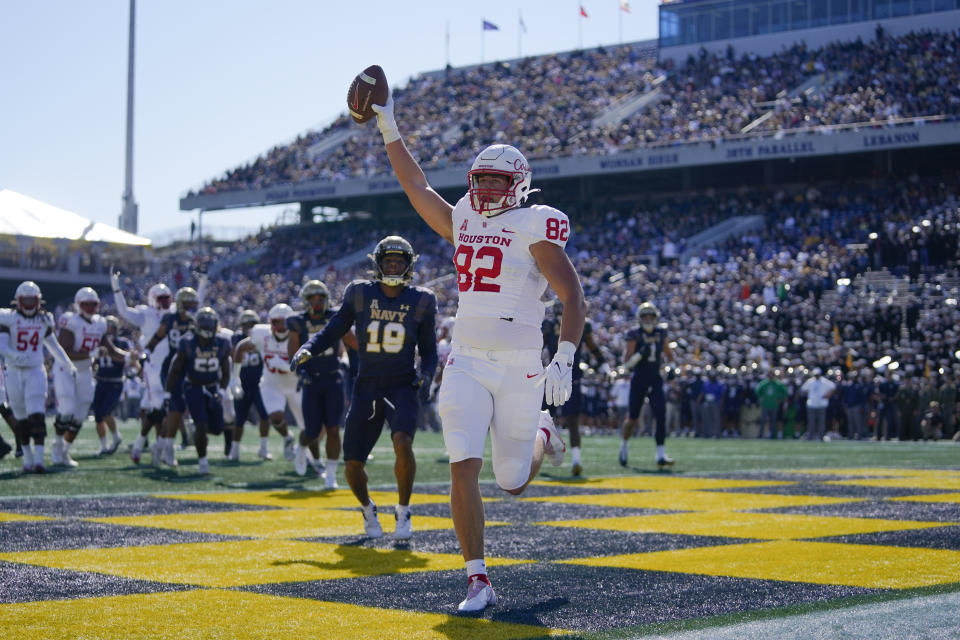 Houston tight end Matt Byrnes, right, reacts after making a touchdown catch in front of Navy safety Rayuan Lane III (18) during the first half of an NCAA college football game, Saturday, Oct. 22, 2022, in Annapolis, Md. (AP Photo/Julio Cortez)