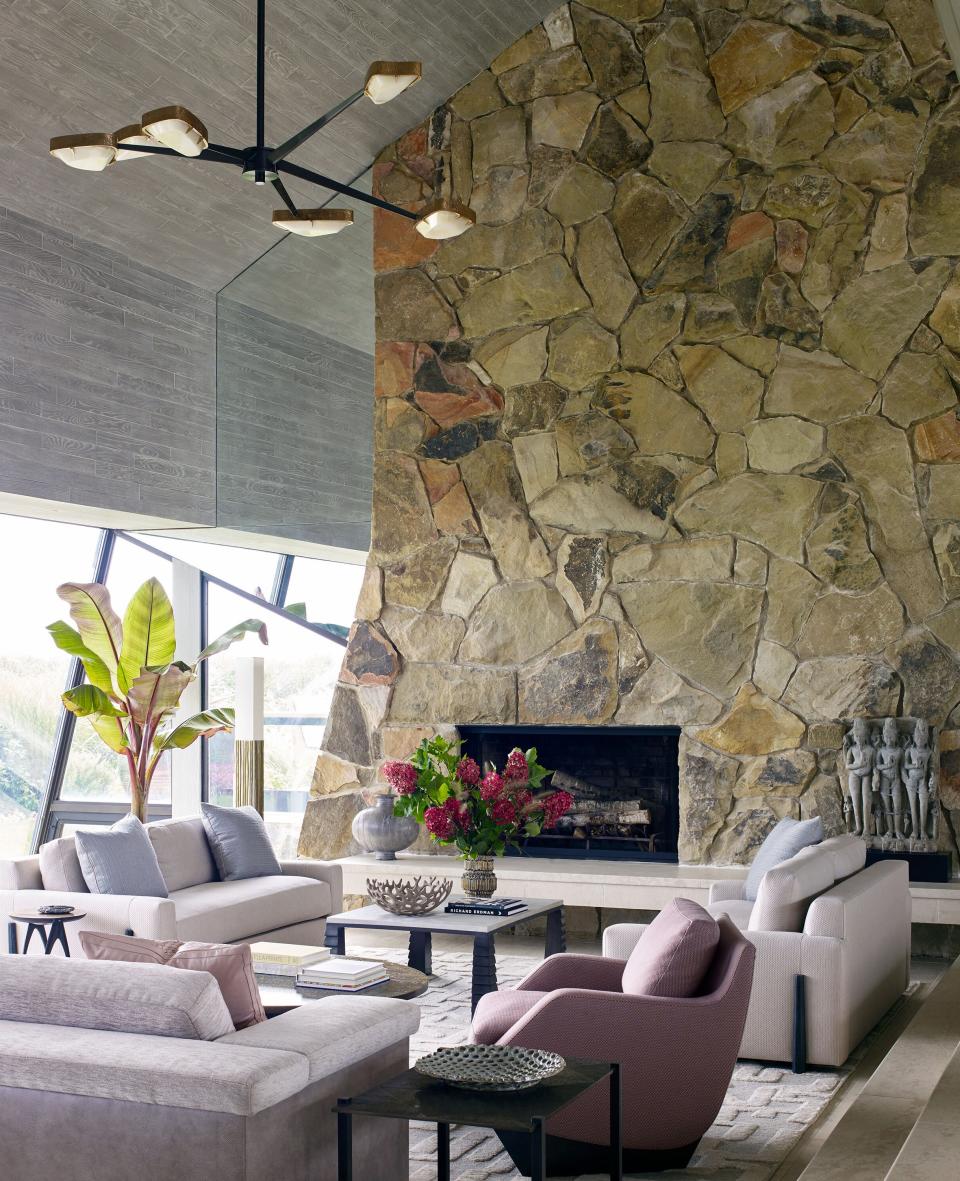 In the sunken living room, which is part of a vast open space with ceilings that rise up to 30 feet, Moon created a set of side-by-side parlors. “It’s a very angular house, and I felt it needed a softer edge,” says the designer about the soothing color palette, largely inspired by the surrounding seascape. Right next to the fireplace, he placed two oyster-hued loveseats with wraparound ebonized legs. The Jean de Merry coffee table between them has bronze legs and a shagreen leather top. In the foreground we see a curvaceous armchair by Georgis & Mirgorodsky for Maison Gerard.