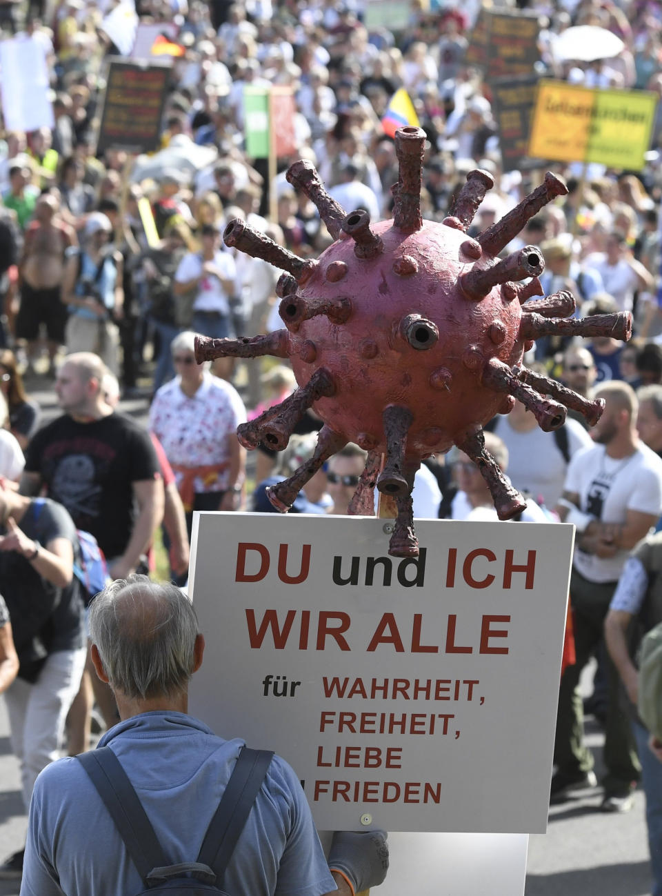 Participants of a demonstration protest with signs on the Rhine meadows against the measures to combat the coronavirus in Duesseldorf, Germany, Sunday, Sept.20, 2020. Sign reads "you and m , we all for truth , freedom, love, peace.".(Roberto Pfeil/dpa via AP)