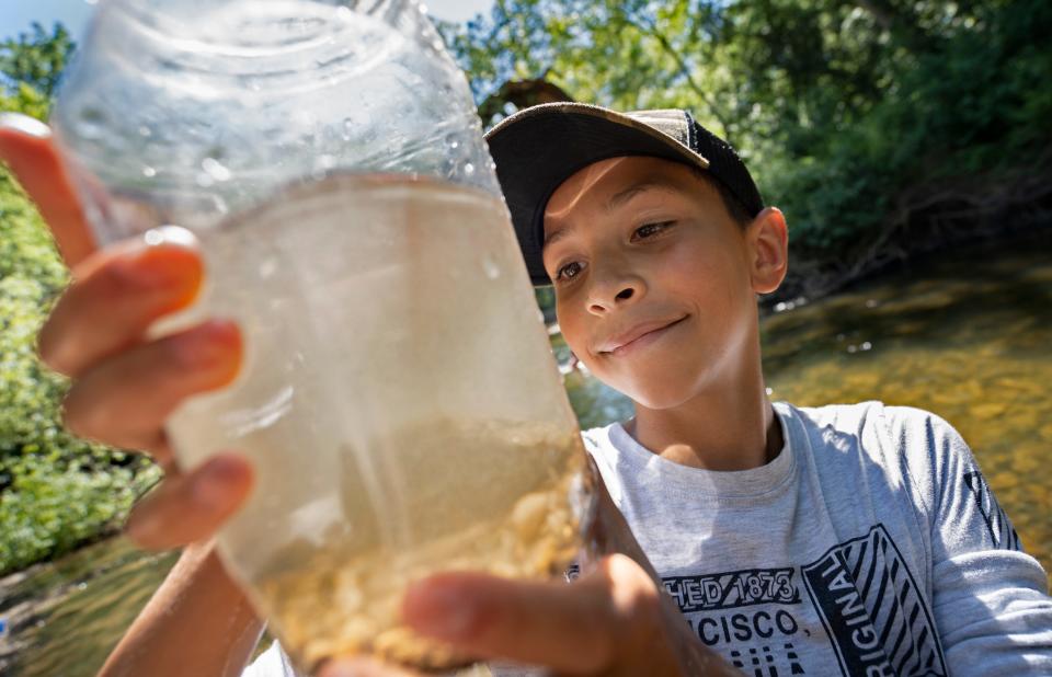 Mahki Alexander takes a sample from Fall Creek as he looks for microinvertebrates Thursday, June 30, 2022 at Fort Harrison State Park. Share LT students from Belzer Middle School and Fall Creek Valley Middle School canoed, fished, hiked and did a creek study with Camptown.