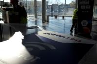 Employees work next to a banner with information of MWC20 in Barcelona