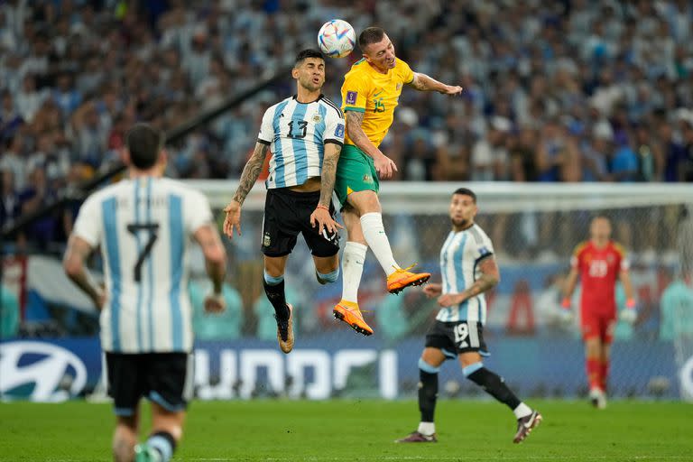 Cristian Romero lucha por la pelota con Mitch Ducke durante el partido que disputan Argentina y Australia, por los octavos de final de la Copa del Mundo Qatar 2022 en el estadio Ahmed bin Ali, Umm Al Afaei, Qatar, el 3 de diciembre de 2022.