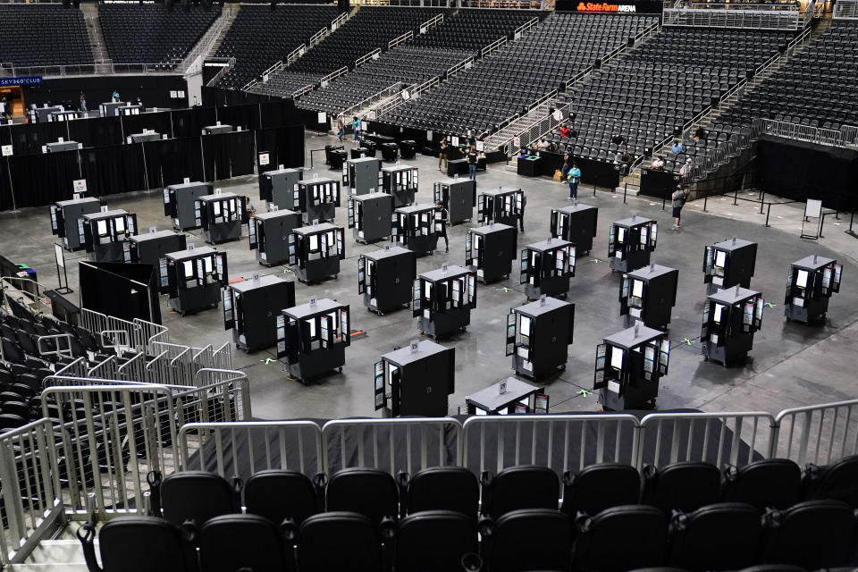Voting machines fill the floor for early voting at the State Farm Arena on Monday, Oct. 12, 2020, in Atlanta. (AP Photo/Brynn Anderson)