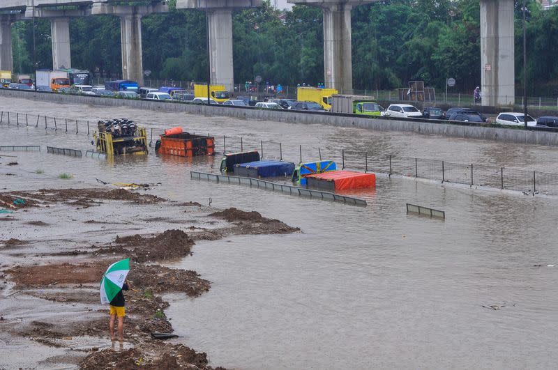 Trucks are seen partially submerged along the Jakarta-Cikampek Toll Road in Bekasi, near Jakarta