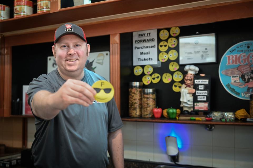 Italian Village Pizza owner Ryan Marquardt shows one of his "pay-it-forward' meal tickets Thursday, Feb. 1, 2024, at his pizza shop in the Lansing Mall.